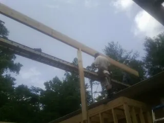 Carpenter setting a ridge beam over a new addition frame — Ice Dam Removal by Roofing Brothers in Celina