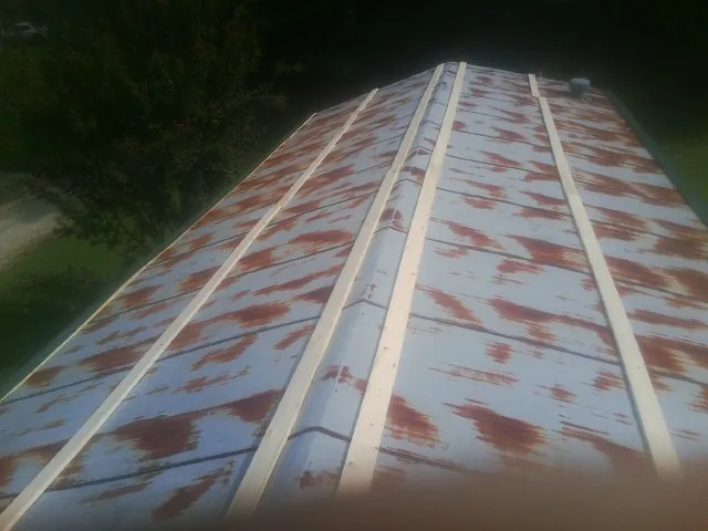 Rusted metal roof panels with new wood purlins before replacement — Storm Damage Roof Repair in Celina by Roofing Brothers